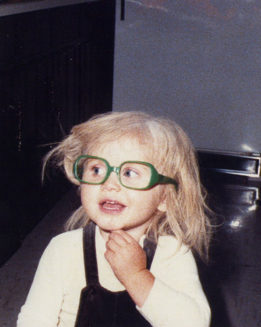 woman in white and black shirt wearing green framed eyeglasses